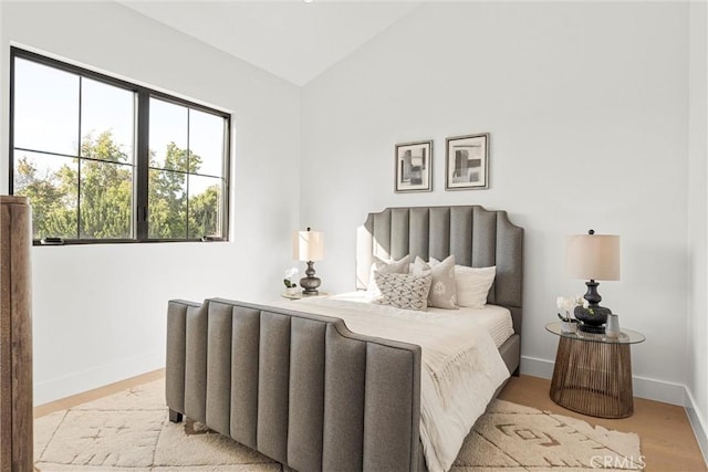 bedroom featuring light hardwood / wood-style flooring and vaulted ceiling