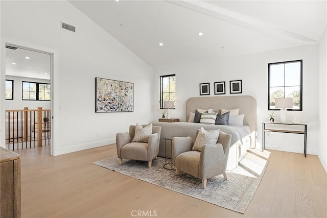 bedroom with light wood-type flooring and high vaulted ceiling