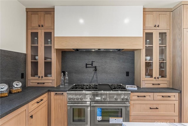 kitchen with decorative backsplash, light brown cabinets, premium range hood, and range with two ovens