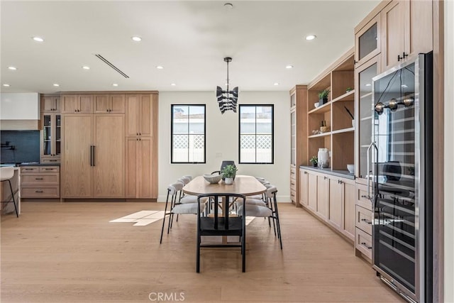 dining area featuring wine cooler and light hardwood / wood-style flooring