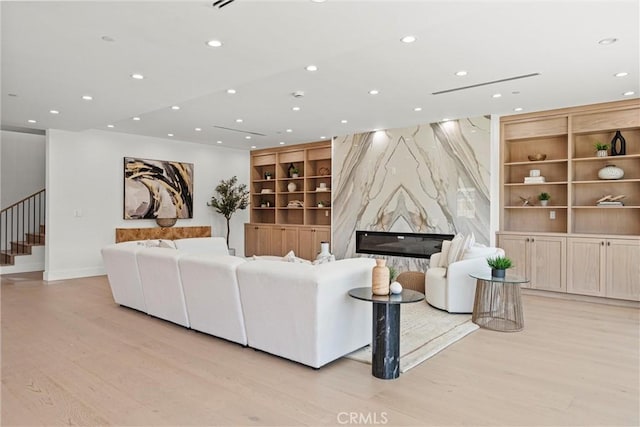 living room with light hardwood / wood-style flooring and a high end fireplace