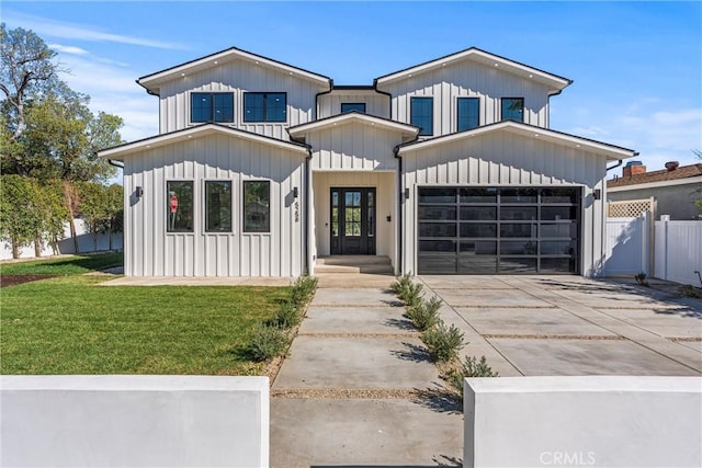 modern farmhouse featuring a garage, french doors, and a front lawn