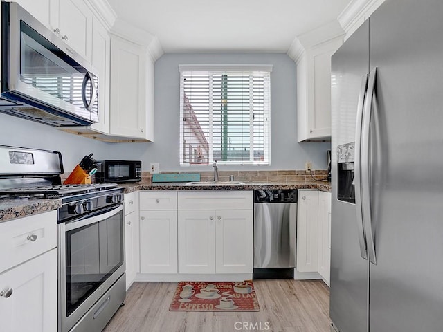 kitchen featuring light hardwood / wood-style floors, white cabinetry, stainless steel appliances, and sink