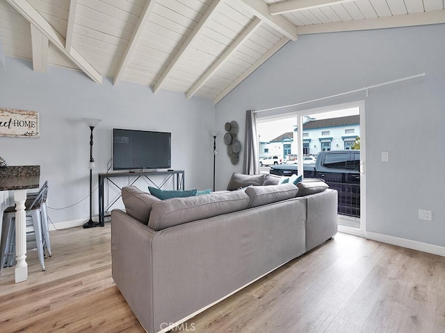 living room with light wood-type flooring and vaulted ceiling with beams