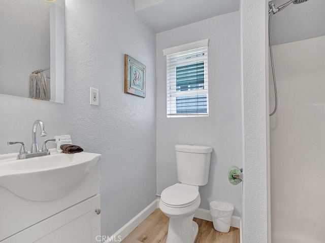 bathroom featuring hardwood / wood-style floors, vanity, toilet, and walk in shower