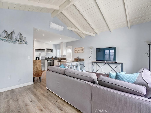 living room featuring vaulted ceiling with beams, a wall mounted air conditioner, and light hardwood / wood-style flooring