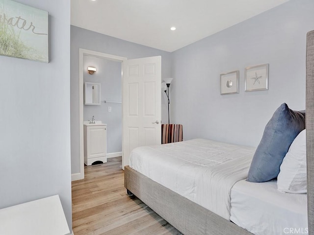 bedroom with light hardwood / wood-style flooring and sink