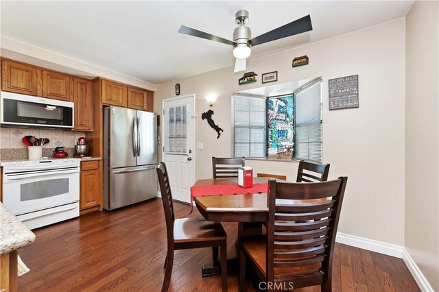 dining room with ceiling fan and dark wood-type flooring