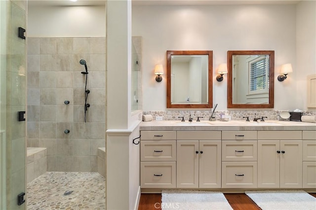 bathroom featuring vanity, decorative backsplash, wood-type flooring, and walk in shower