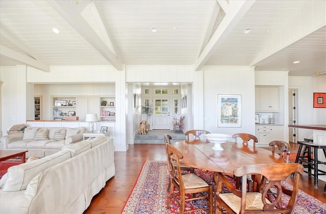 dining room with lofted ceiling with beams and wood finished floors