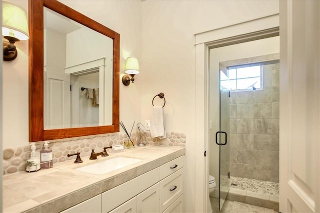 full bath with a shower stall, vanity, and toilet