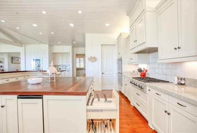kitchen featuring light wood-type flooring, backsplash, gas cooktop, and wooden counters