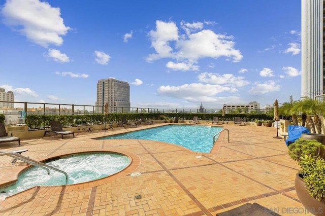 view of pool featuring a community hot tub and a patio