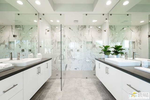 bathroom with walk in shower, a raised ceiling, and vanity