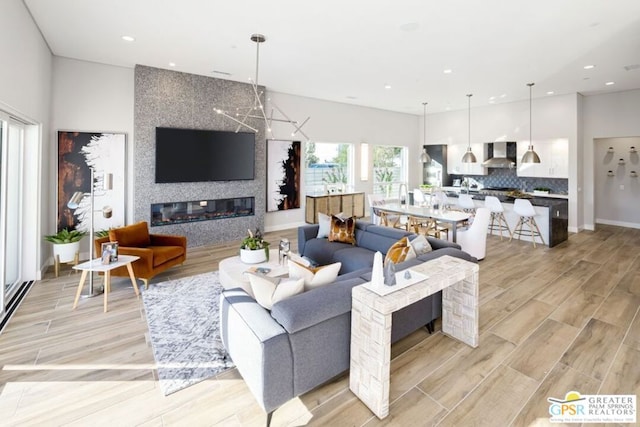 living room featuring light wood-type flooring and a large fireplace