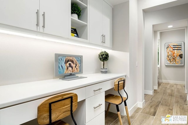 office area featuring light wood-type flooring and built in desk