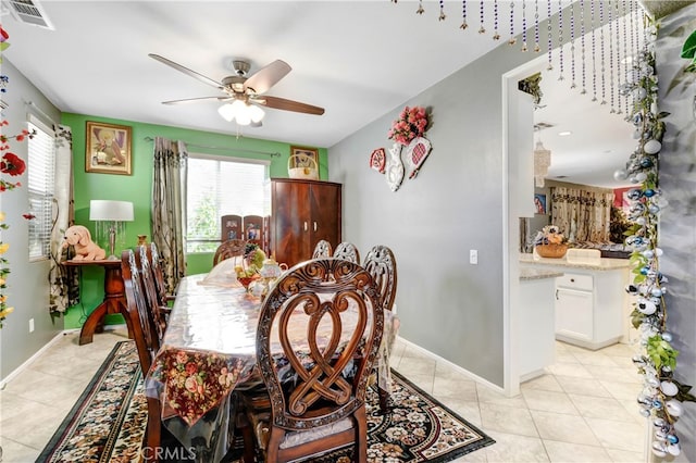 tiled dining space with ceiling fan