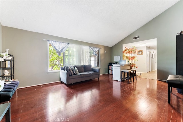 living room featuring dark wood-type flooring and high vaulted ceiling