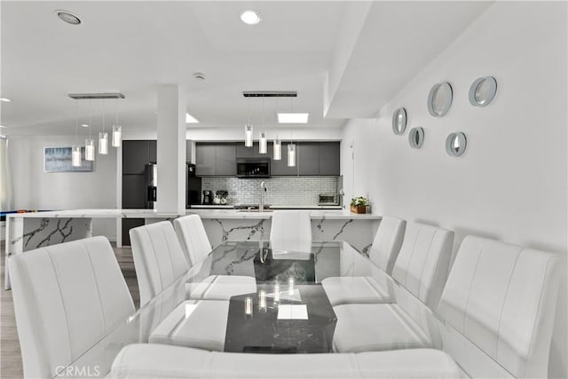 dining area featuring light wood-type flooring and sink