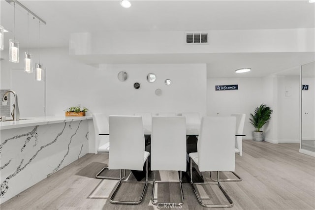 dining area featuring sink and light hardwood / wood-style flooring