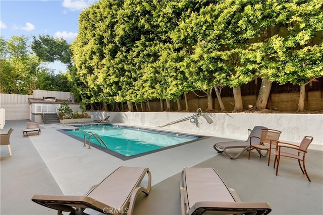 view of pool with a patio area and an outdoor kitchen