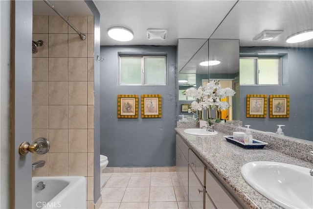 full bathroom featuring toilet, plenty of natural light, vanity, and tile patterned flooring