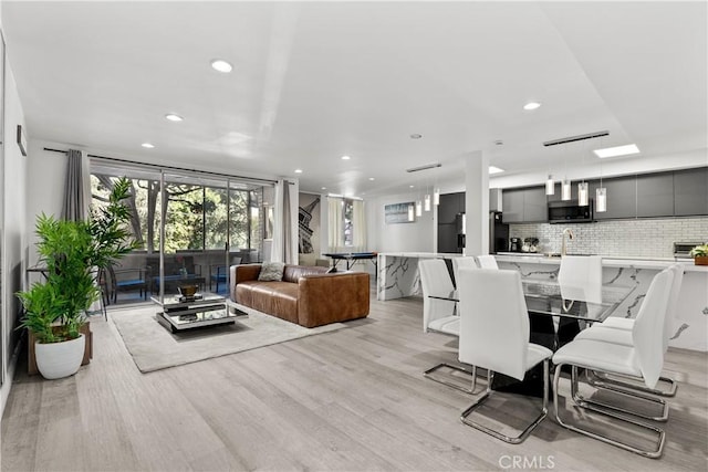 dining space with sink and light hardwood / wood-style flooring