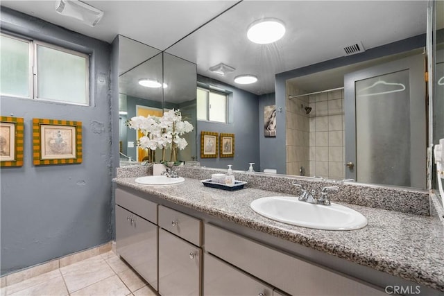 bathroom featuring tiled shower, vanity, and tile patterned floors