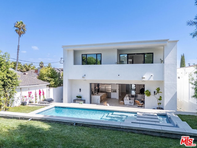 rear view of house featuring a fenced in pool