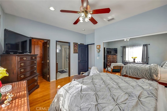 bedroom featuring ceiling fan, ensuite bathroom, and light wood-type flooring