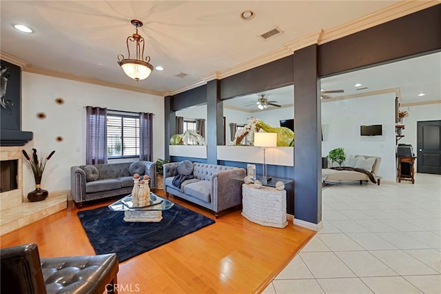 living room featuring ceiling fan, light tile patterned flooring, and ornamental molding