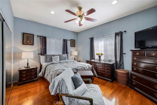 bedroom with a closet, hardwood / wood-style flooring, and ceiling fan