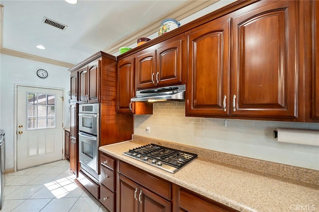 kitchen with backsplash, light tile patterned floors, stainless steel appliances, and ornamental molding