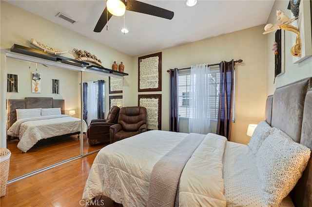 bedroom with hardwood / wood-style flooring, ceiling fan, and a closet