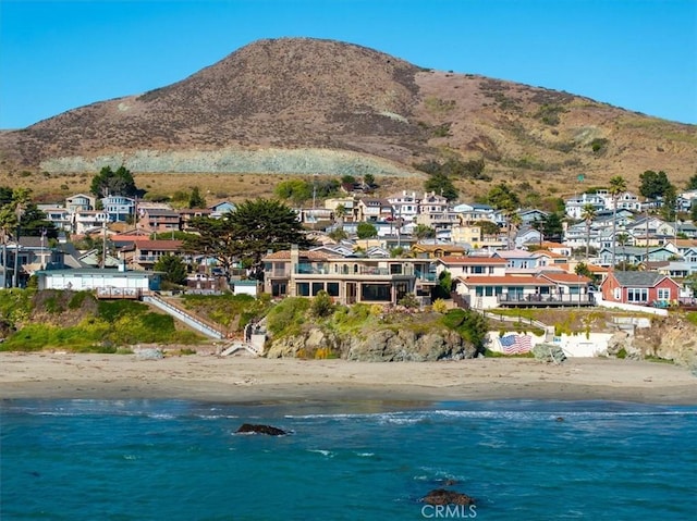 exterior space featuring a water and mountain view and a beach view