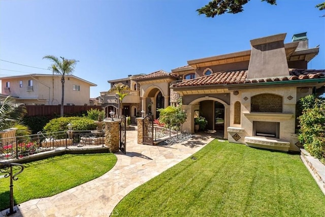 view of front facade with a front lawn and exterior fireplace