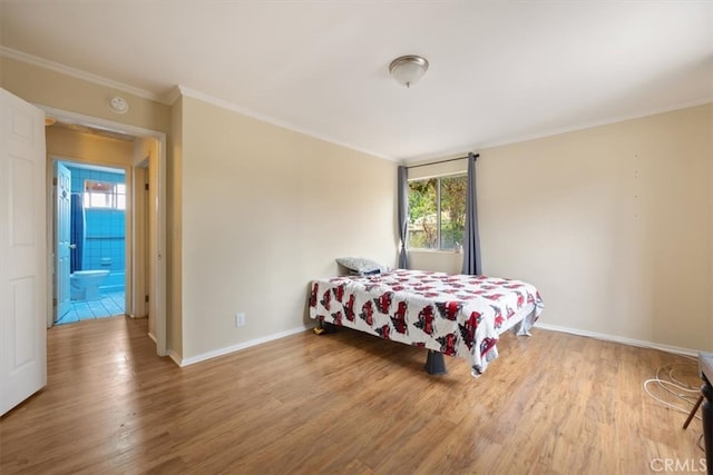 bedroom with ensuite bath, multiple windows, hardwood / wood-style floors, and crown molding