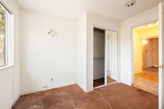 unfurnished bedroom featuring carpet flooring and a closet