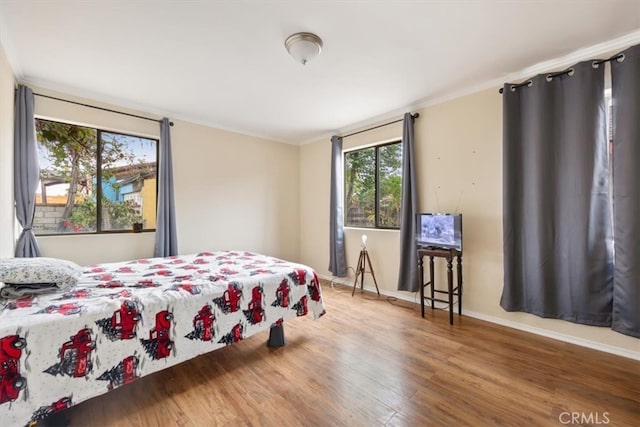 bedroom with wood-type flooring and ornamental molding