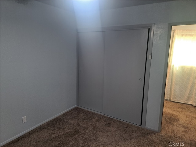 unfurnished bedroom with carpet floors and a closet