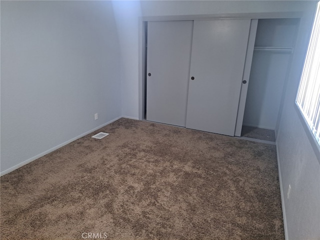 unfurnished bedroom featuring a closet and carpet flooring