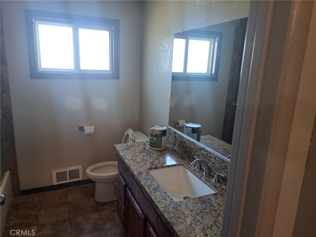 bathroom with vanity, toilet, and tile patterned floors