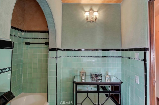 bathroom featuring tile walls and separate shower and tub