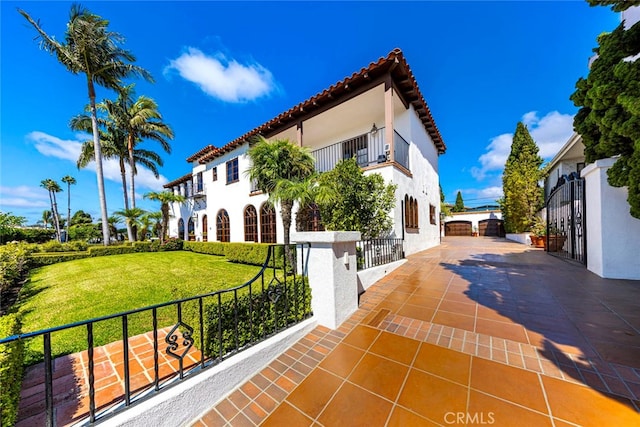 view of front of home featuring a balcony and a front lawn