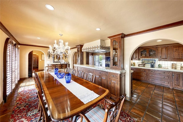 tiled dining space featuring a notable chandelier and crown molding