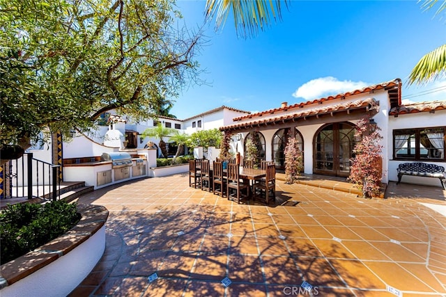 view of patio / terrace with area for grilling, an outdoor kitchen, and french doors