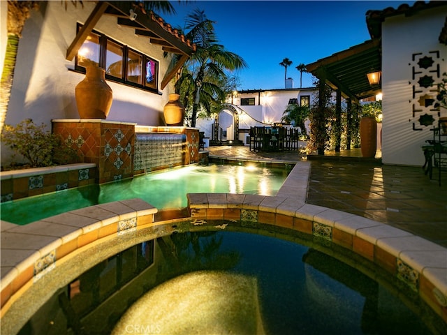 view of pool with pool water feature, an in ground hot tub, and a patio area