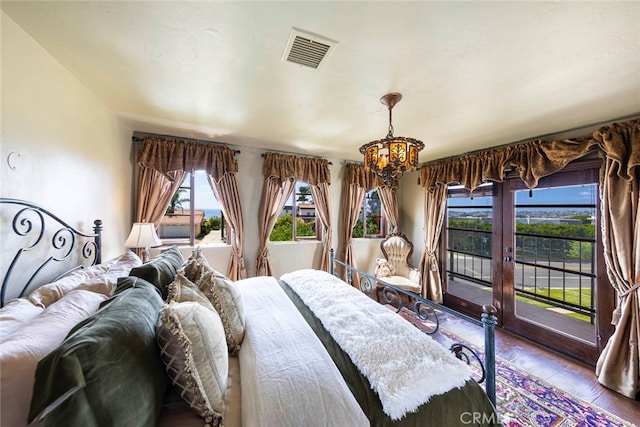 bedroom featuring a notable chandelier, hardwood / wood-style floors, and access to exterior