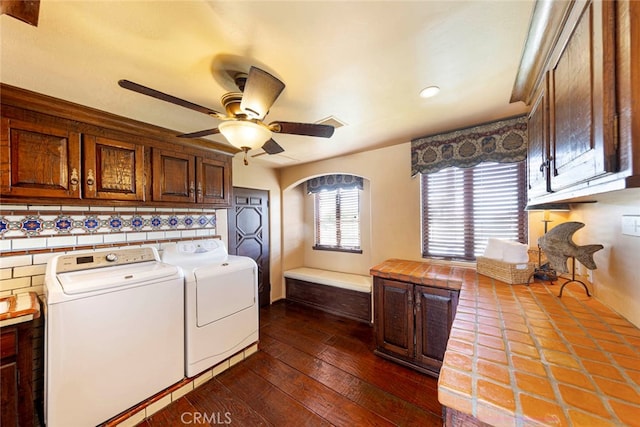 clothes washing area with washer and clothes dryer, cabinets, dark hardwood / wood-style flooring, and ceiling fan