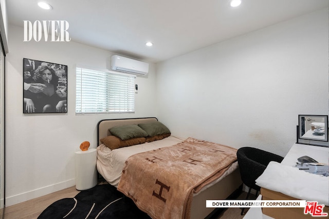 bedroom with light wood-type flooring and a wall mounted AC